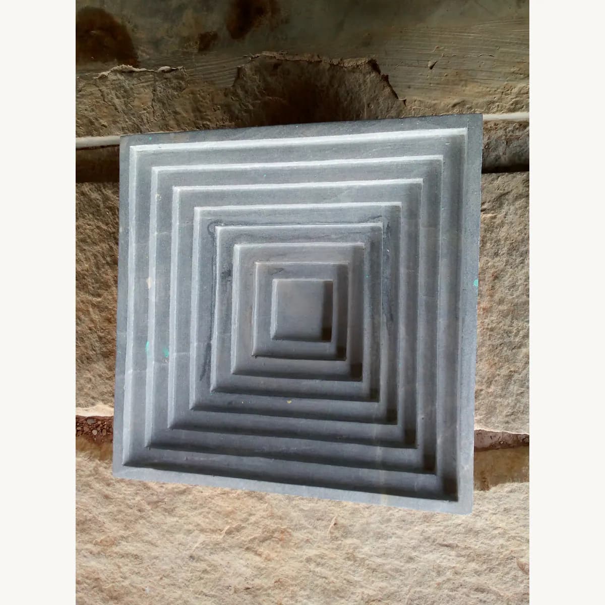 Carved stone diya detail for puja decor